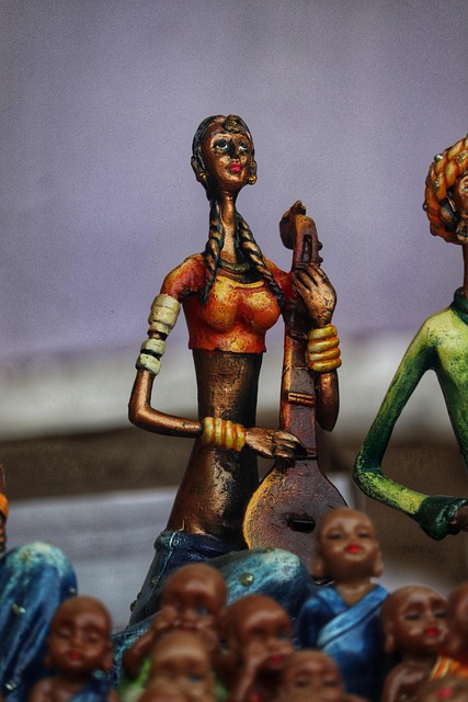 Decorative antique objects including porcelain figurines, bronze sculptures, carved wooden boxes, snuff boxes, displayed on shelves with warm lighting