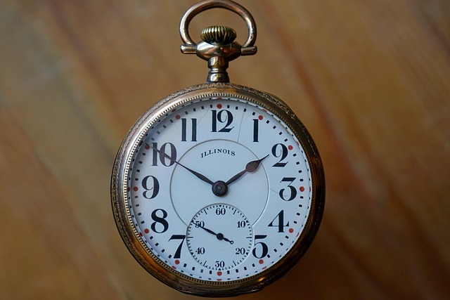 Antique Swiss pocket watch with open case showing intricate movement, gold case, white enamel dial, Roman numerals, on dark leather